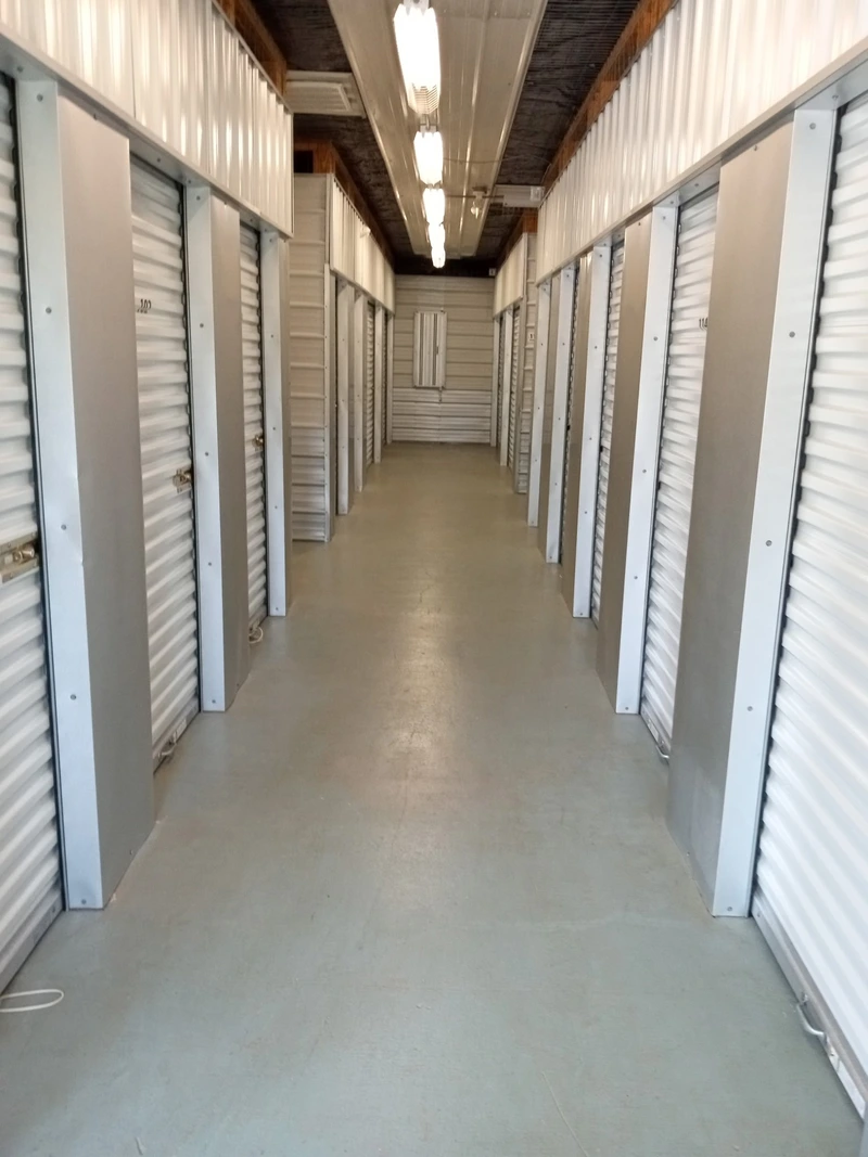 A long hallway lined with storage units in a self-storage facility, showcasing organized and accessible storage options